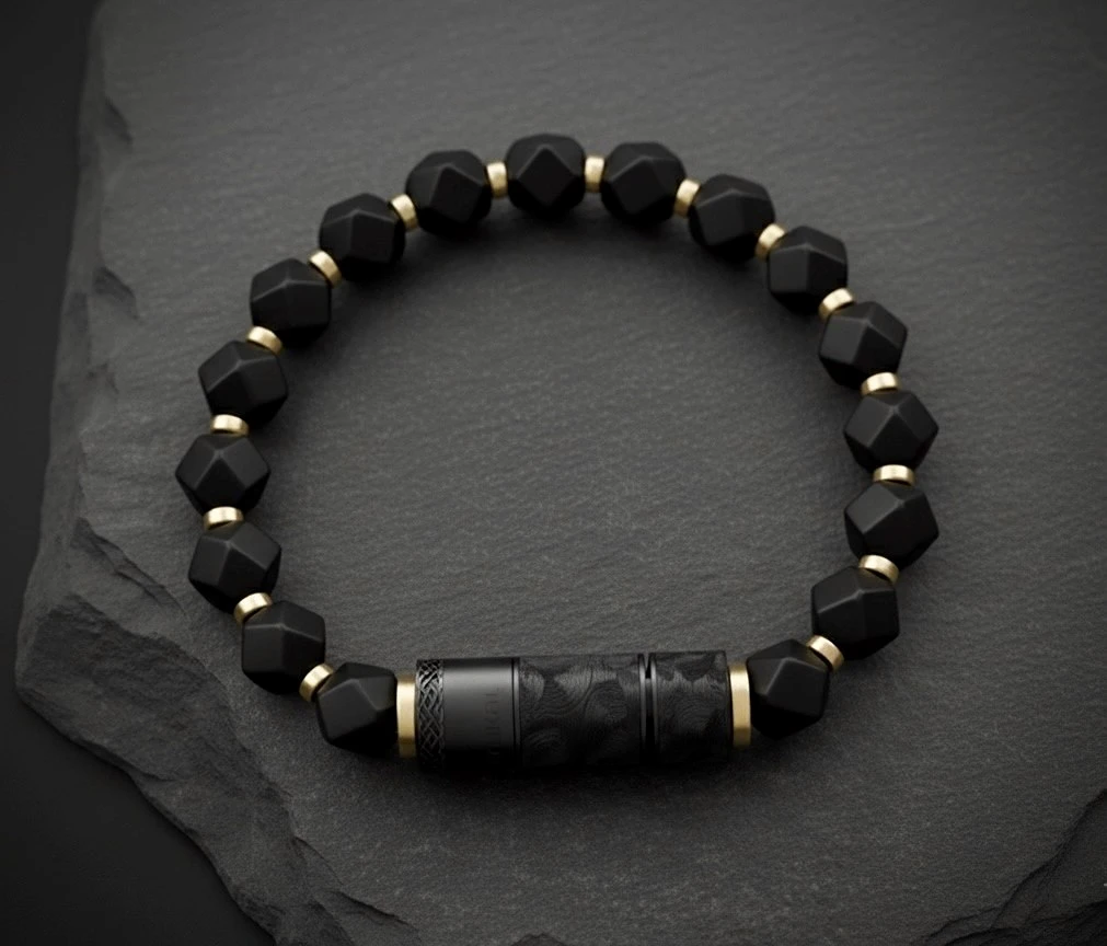 O-Punch Black Edition – top view, faceted obsidian beads with gold spacers and black engraved punch tool on dark stone