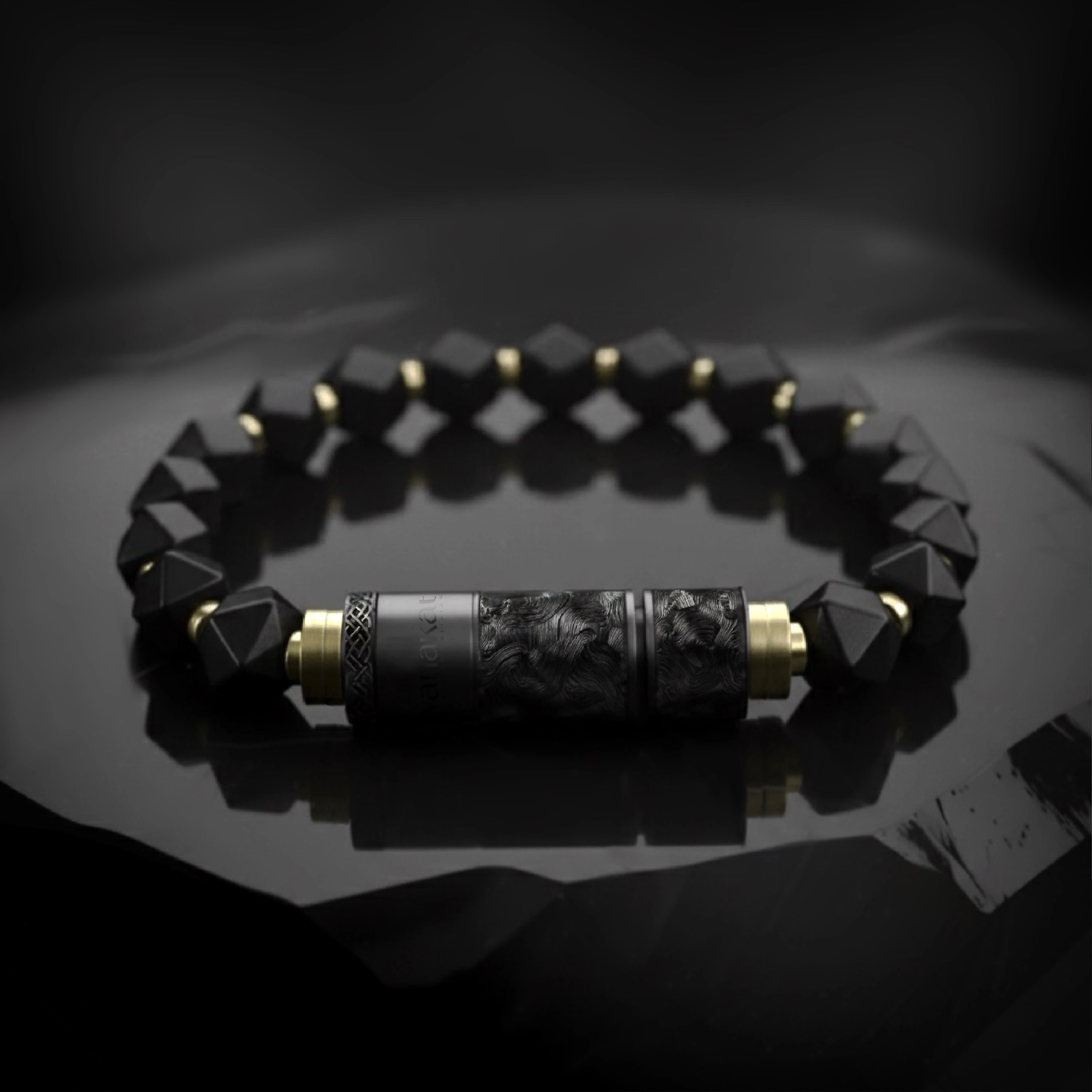 O-Punch Black Edition – bracelet laid on reflective dark surface, engraved punch tool detail