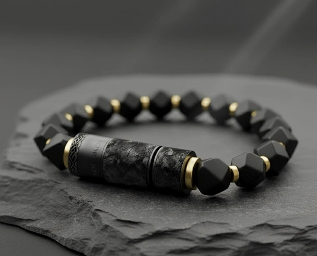 O-Punch Black Edition – bracelet on textured stone, faceted obsidian beads with gold spacers and black engraved punch tool
