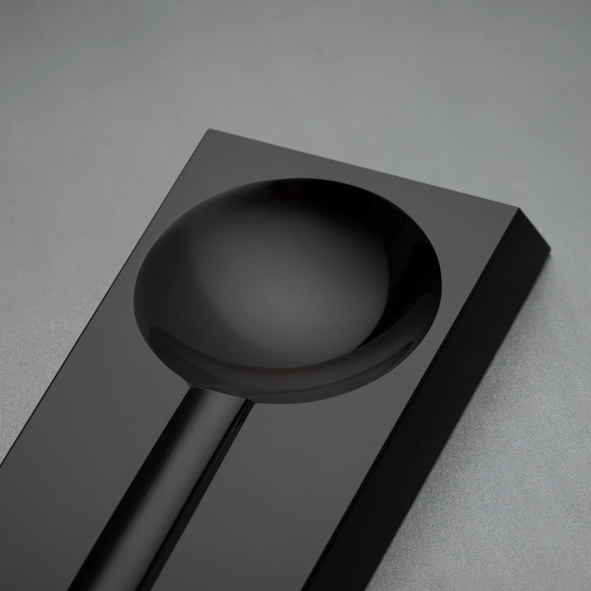 Loupe ashtray — circular bowl machined into obsidian